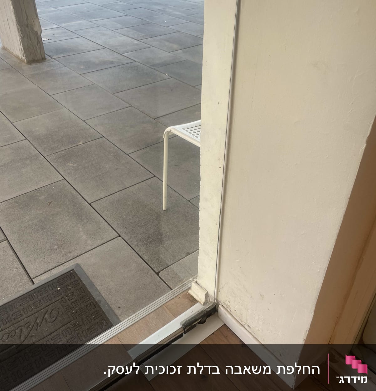 דלת זכוכית עם מסגרת מתכת ליד רצפת עץ